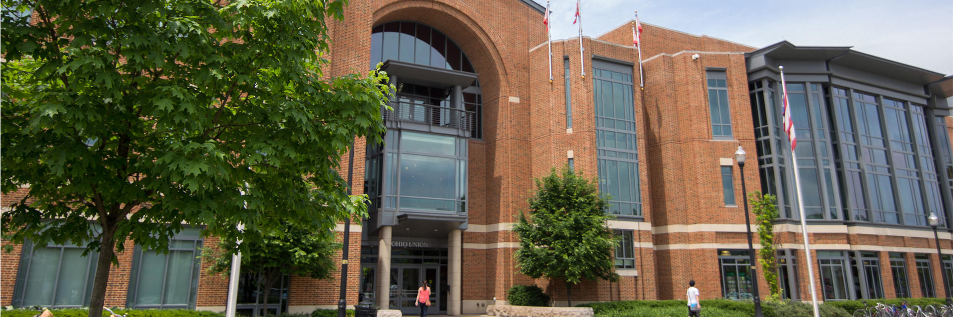 Wide exterior view of the Ohio Union facing College Road, with students walking near the entrance.